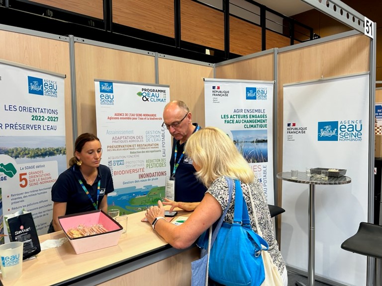 personnes devant le stand de l'agence de l'eau 